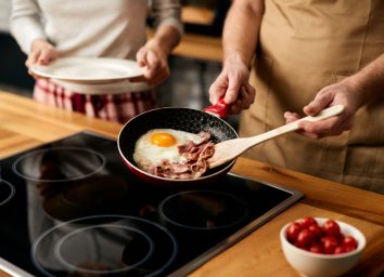 man cooking bacon and eggs