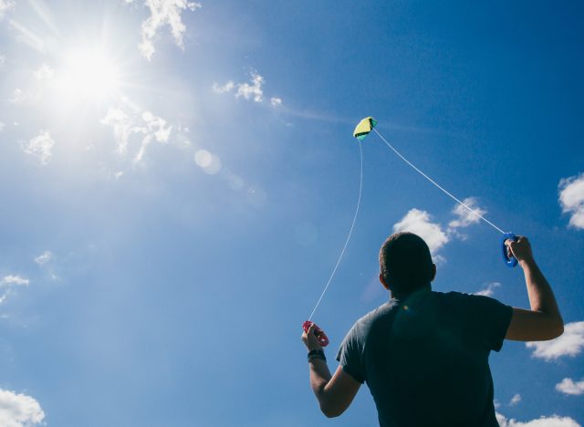man flying kite at the beach