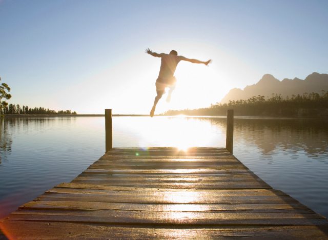 man jumping into lake, keeping in shape after 40