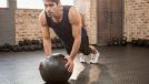 man performing medicine ball exercise to burn gut fat