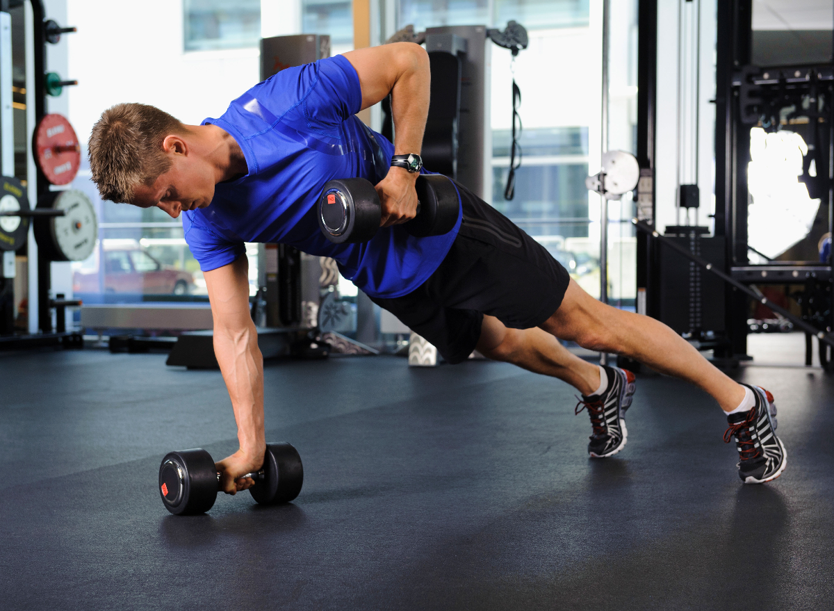 man performing renegade row in gym to shrink belly fat faster