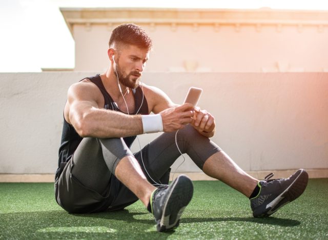 man using phone during exercise break