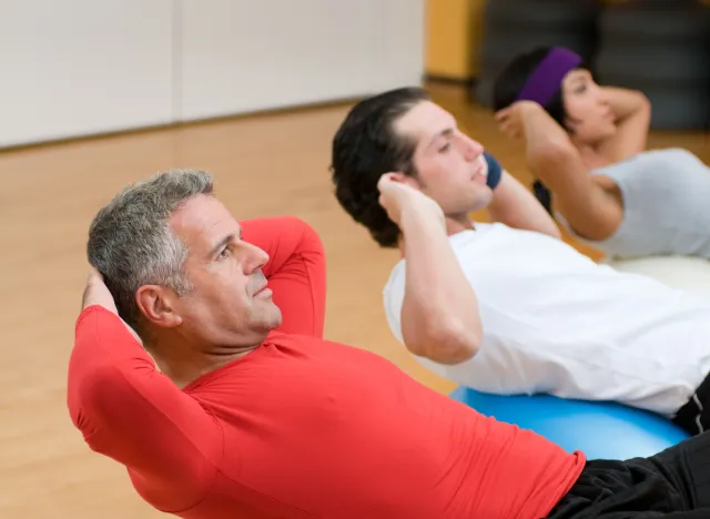 mature man doing situps as part of middle-aged workout group class