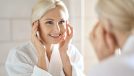 mature woman fight signs of aging with facial massage in bright bathroom