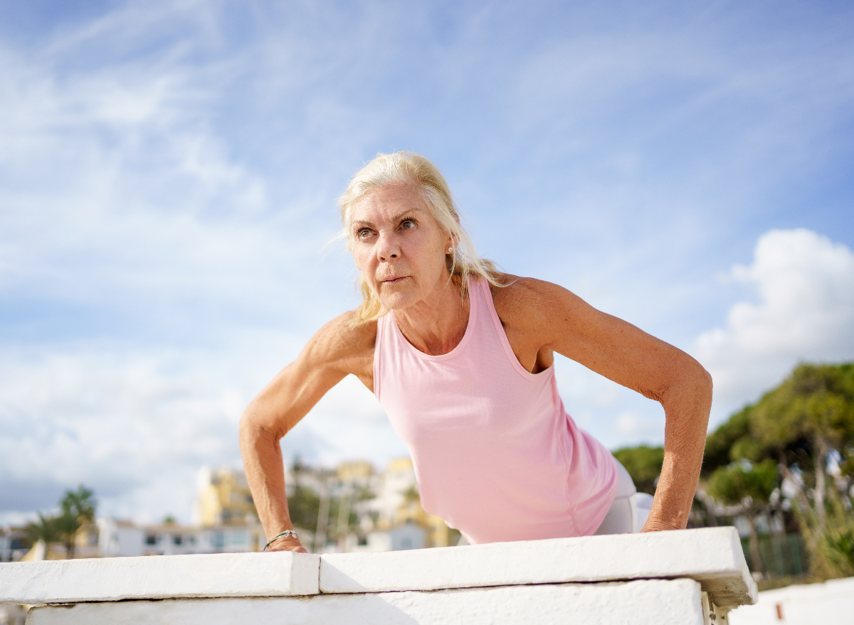 mature woman doing pushups outdoors to get rid of chicken wings