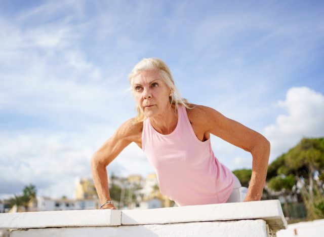 mature woman doing pushups, demonstrating the strength training habits that slow aging