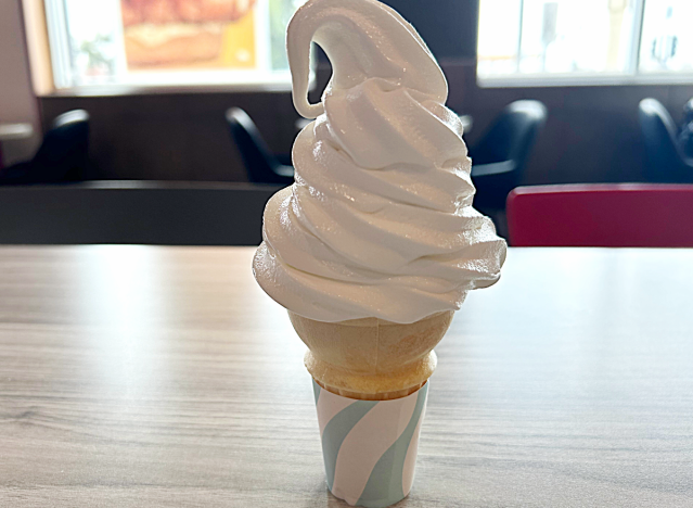 a soft serve vanilla ice cream cone on a table at mcdonalds