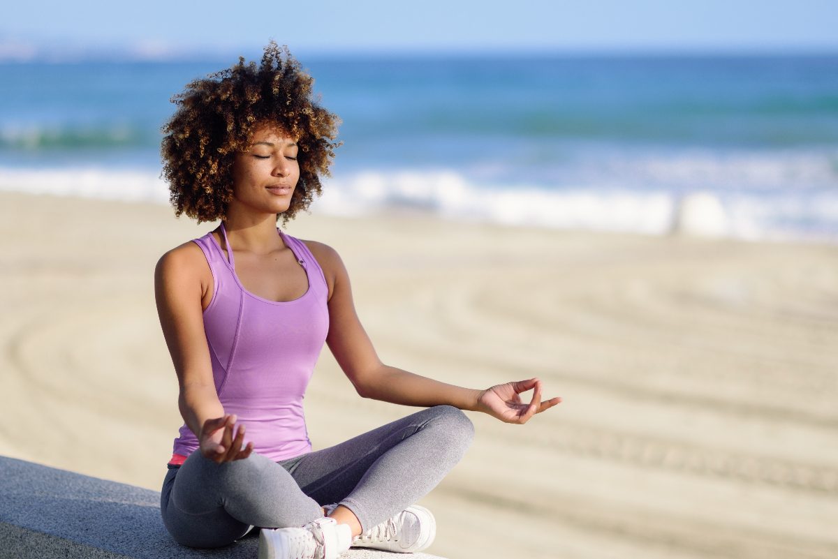 woman meditating at beach, habits of healthy people