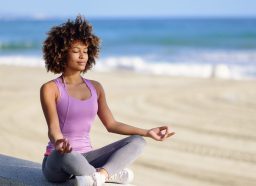 woman meditating at beach, habits of healthy people