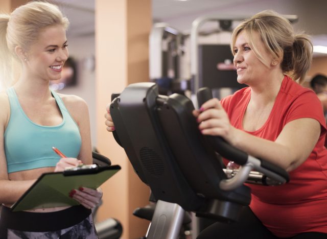 Woman working with her personal trainer at the gym