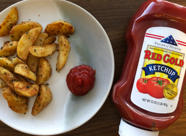 red gold ketchup bottle and fries and ketchup on plate. 