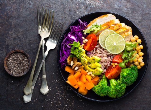 rice bowl with chicken, avocado, veggies, chickpeas, nuts, and seeds