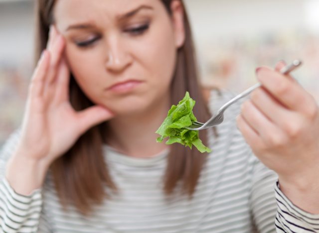 sad woman eating lettuce