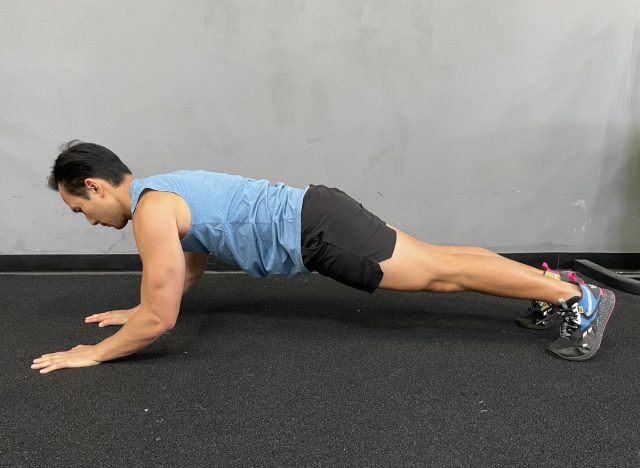 trainer doing triceps pushups, demonstrating exercise to get rid of bat wings