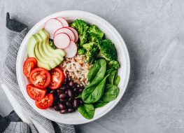 vegan burrito bowl with veggies, avocado, rice, and beans