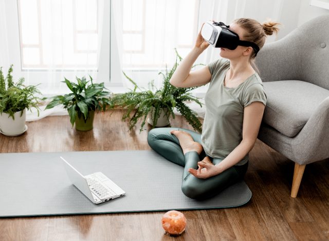 young woman performing virtual workout stress reducer at home