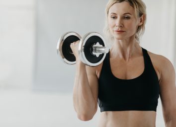 mature woman performs free weight exercises to get rid of arm jiggle