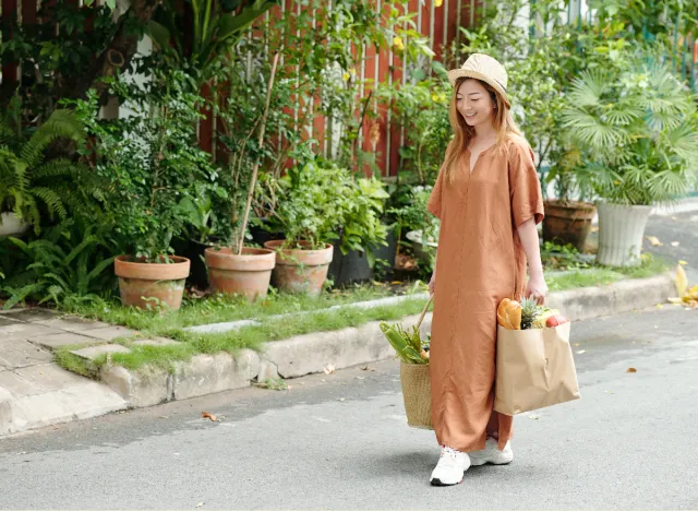 woman carrying groceries outside