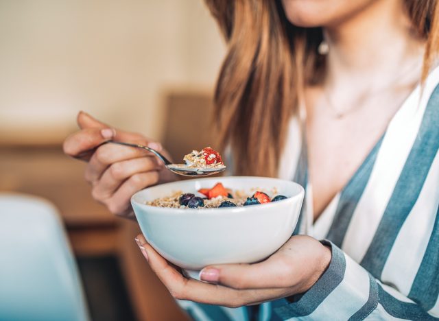 woman eating bowl oatmeal fruit