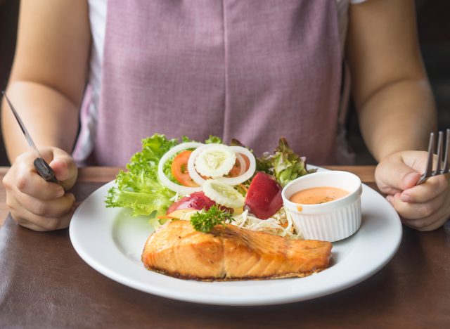 woman eating salmon and salad