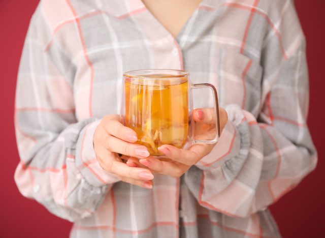 woman holding tea with lemon and ginger