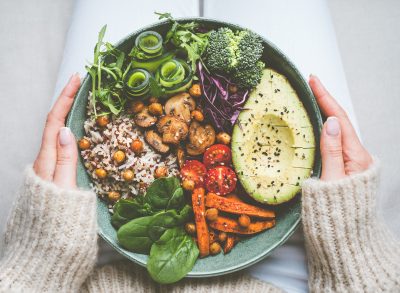 woman holding veggie grain bowl