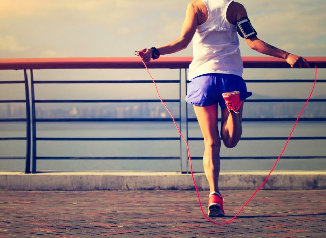 woman jumping rope outside, aerobic exercise to burn fat in your midsection quicker