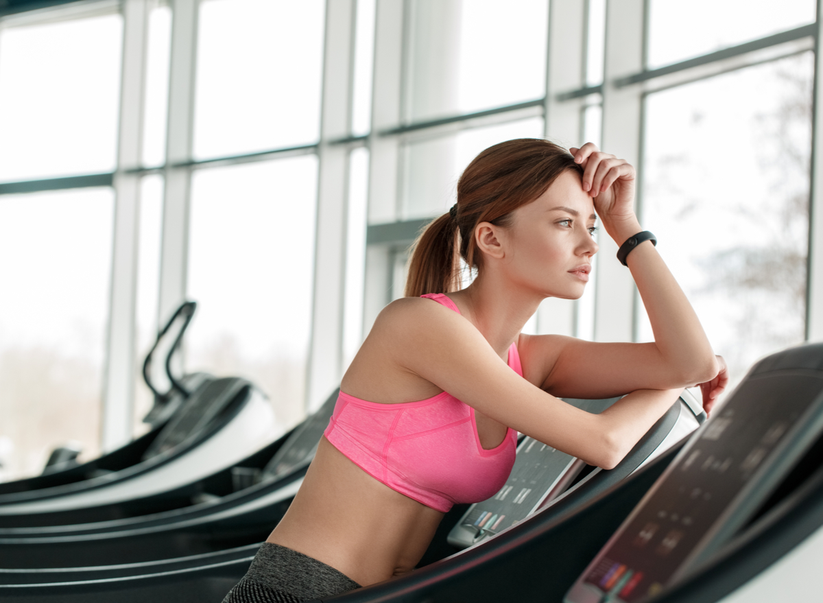 woman leaning on treadmill and looking out the window