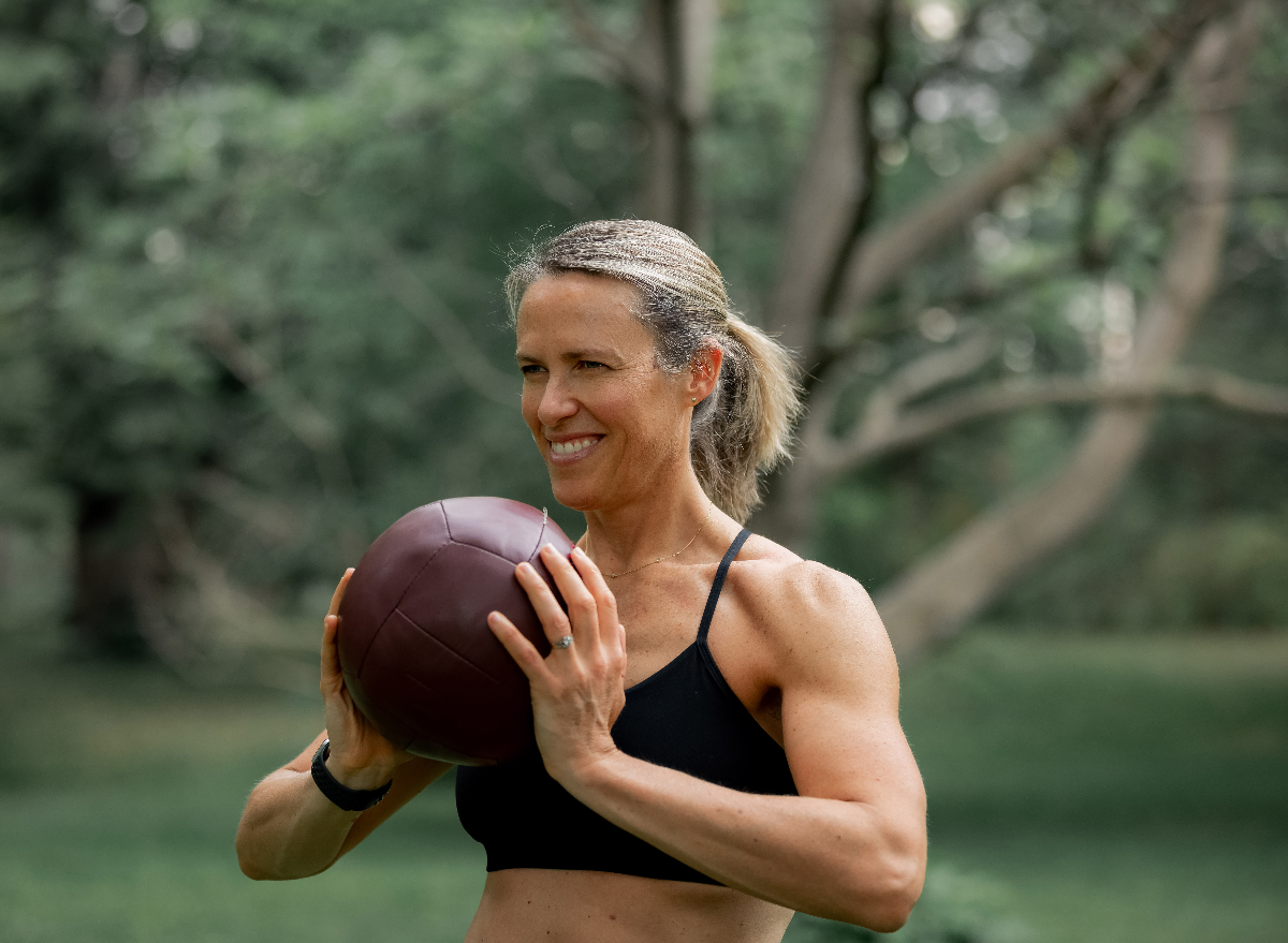 woman performing gut-reducing exercises with medicine ball