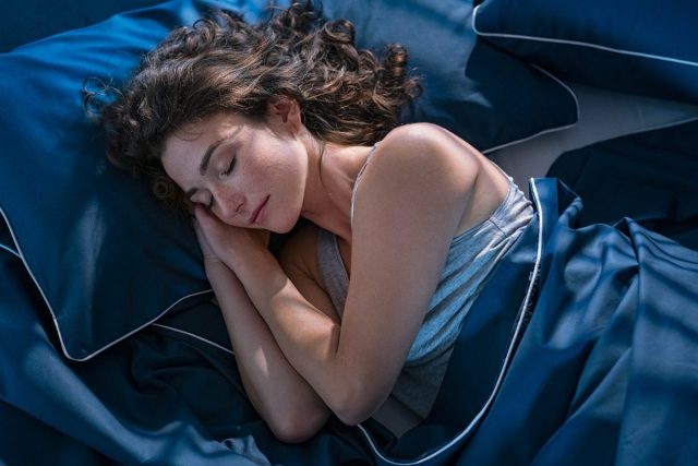 woman peacefully sleeping at night in bed