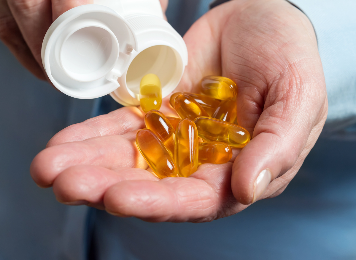 woman pouring omega 3 supplements into hands