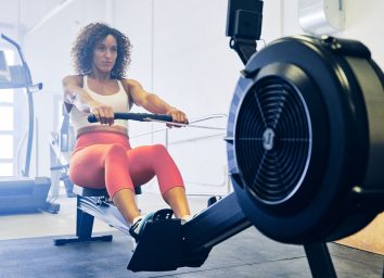 woman rowing demonstrating exercise to shrink fat in your midsection quicker