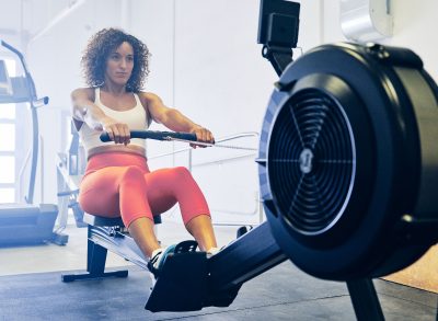 woman rowing demonstrating exercise to shrink fat in your midsection quicker
