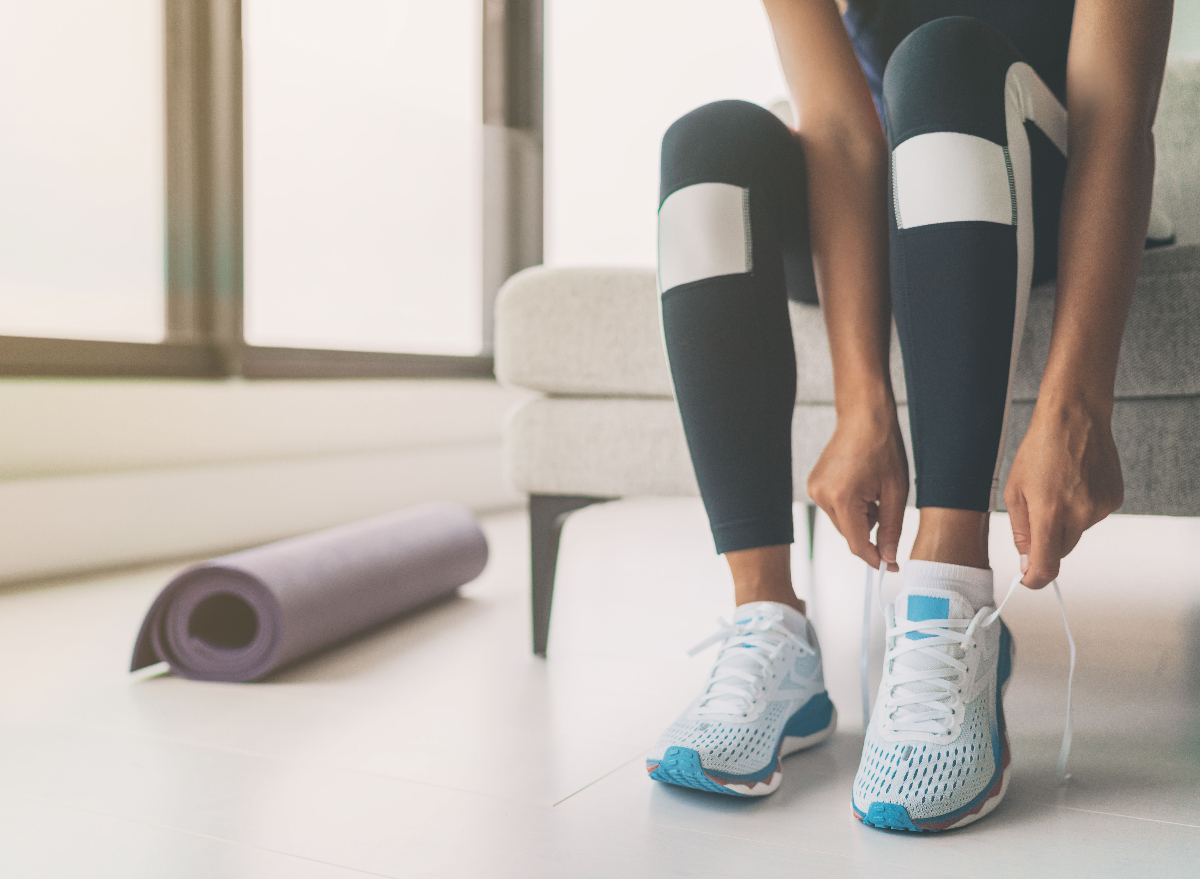 woman tying sneakers getting ready for virtual workout stress reducer