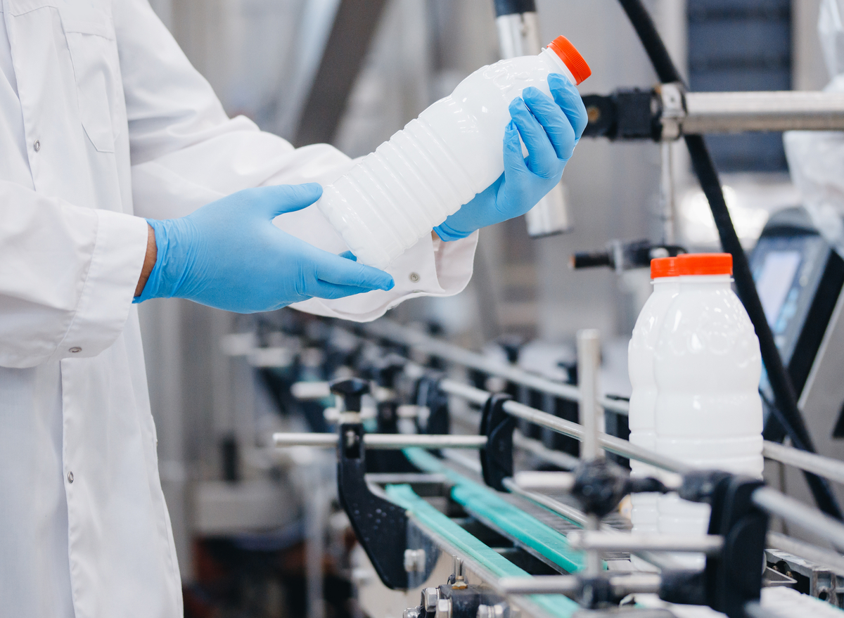 worker inspecting milk bottles