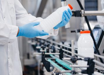worker inspecting milk bottles