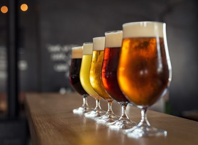 Different types of beer lined up on the bar