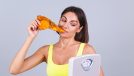 Woman eating pizza and holding scale
