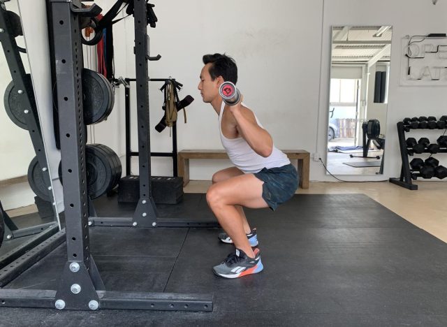 barbell back squat, trainer demonstrating how to lose thigh fat