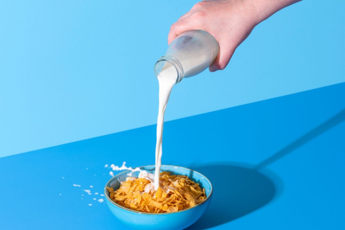 bowl of cereal with milk pouring into it
