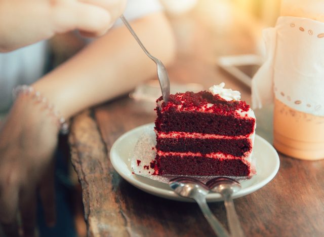 cutting into red velvet cake with spoon