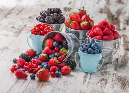 different berries in tin cans