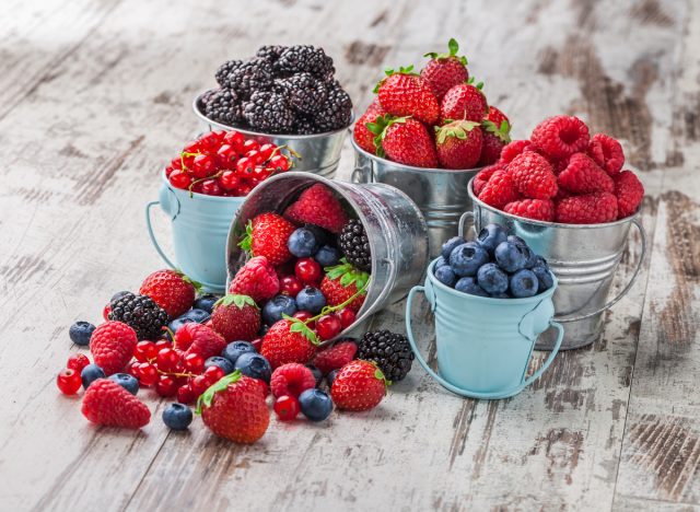 different berries in tin cans