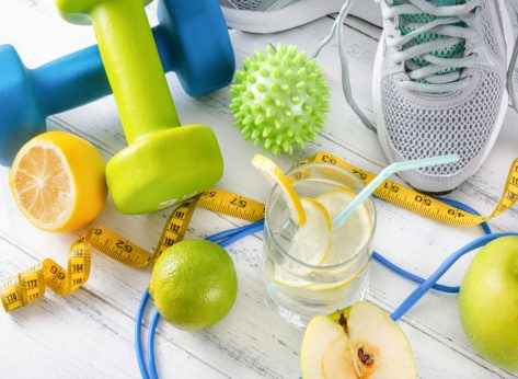 dumbbells, water with lemon, ball, measuring tape, sneakers, and apples