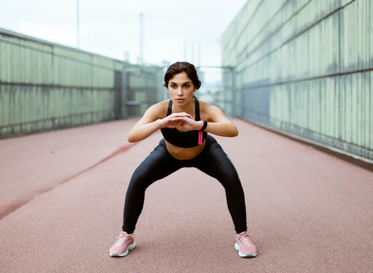 woman demonstrating squat to shrink your stomach