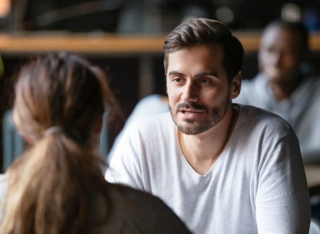 man and woman having serious conversation in coffee shop, close-up