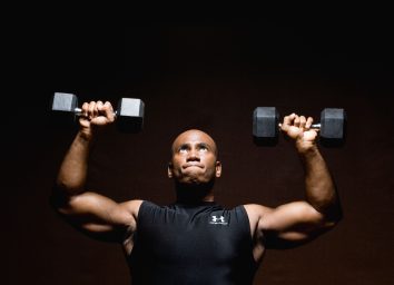 man performing dumbbell exercise to get rid of love handles for good