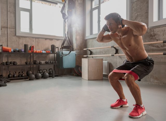 man performing squat exercise to get rid of belly overhang