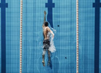 man swimming to manage low blood sugar