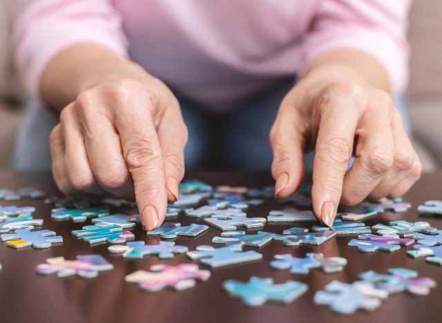 older woman doing a puzzle, demonstrating exercises to keep your brain young